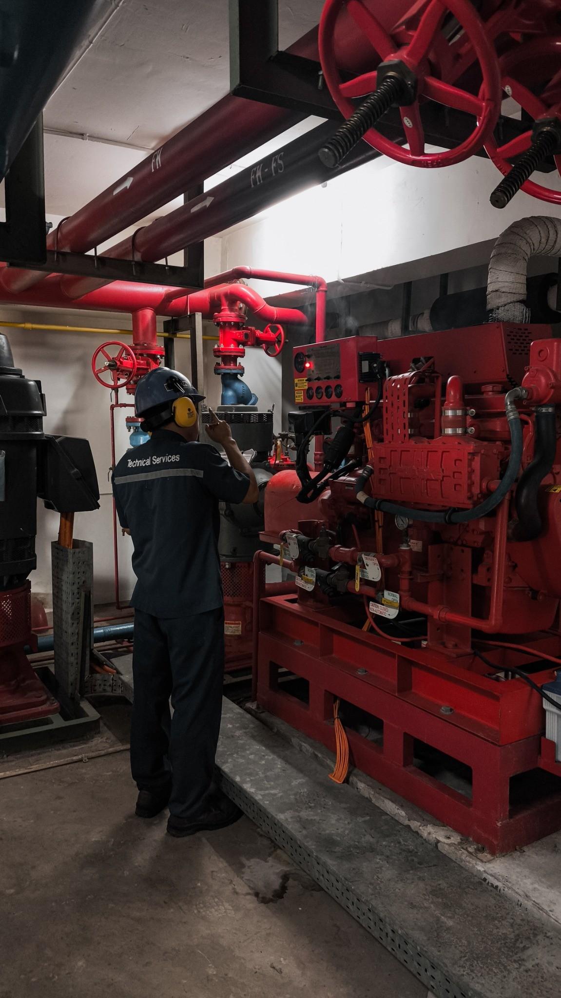 Fire protection technician performing a commercial fire pump inspection and maintenance service inside a mechanical room in the Greater Chicago area.