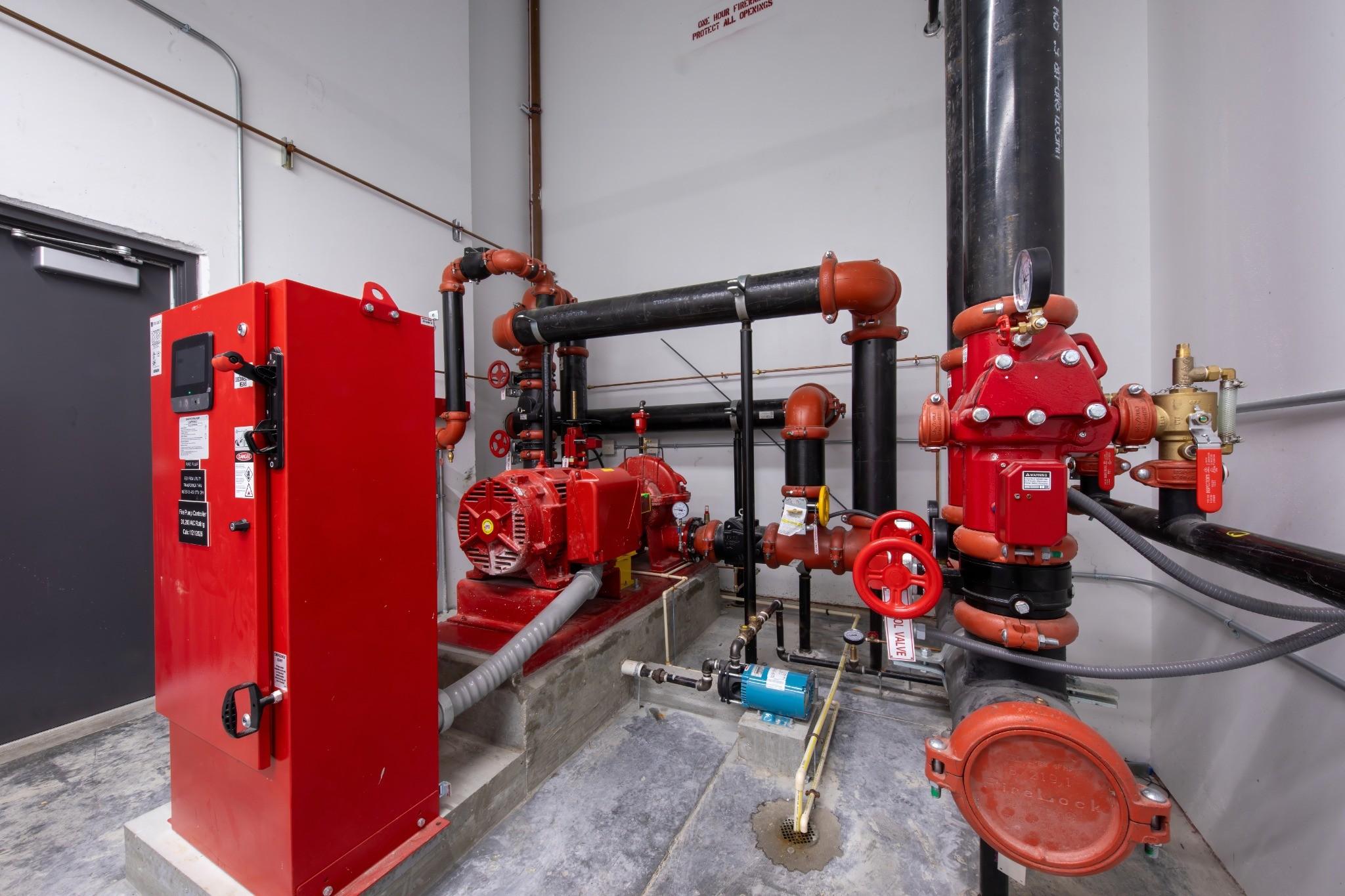 Commercial fire pump room with fire pump, controller, and sprinkler riser assembly