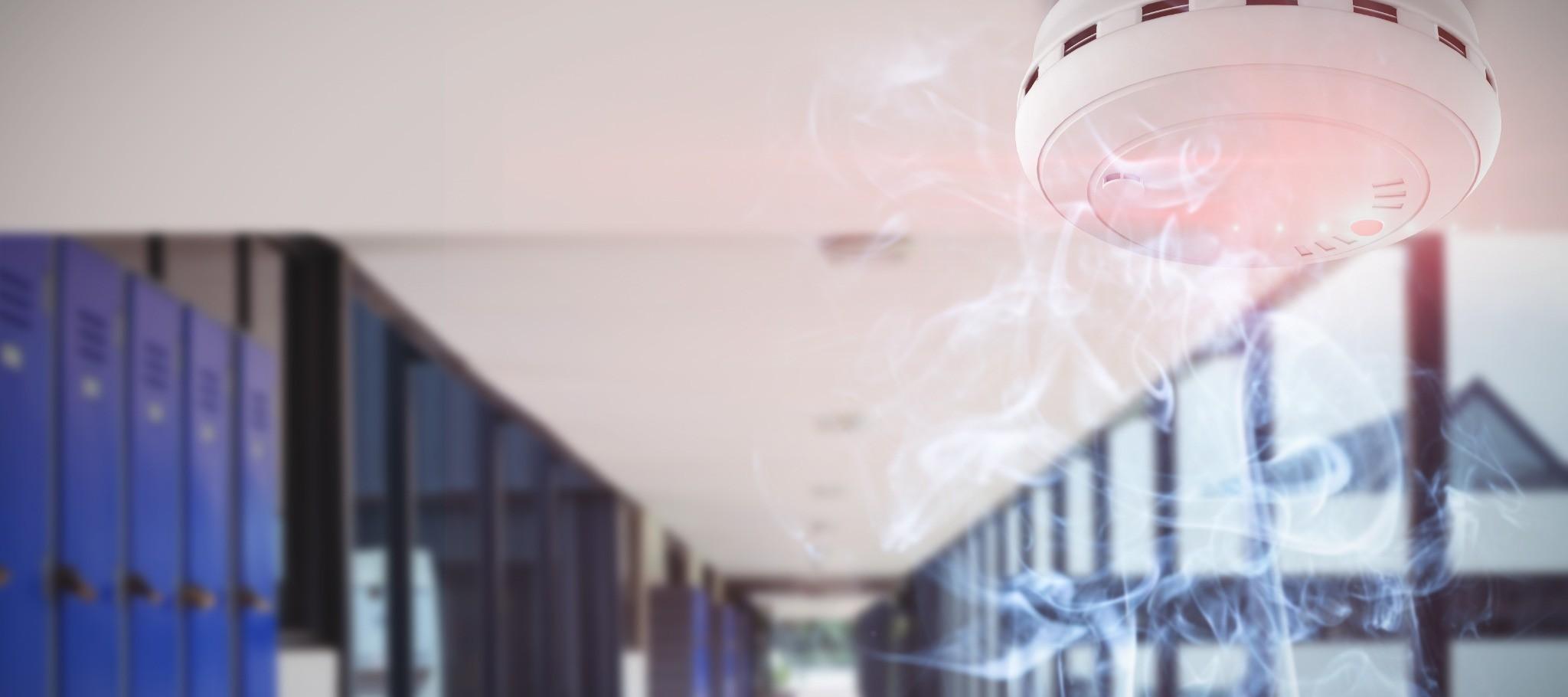 Smoke detector sensing smoke inside a commercial building