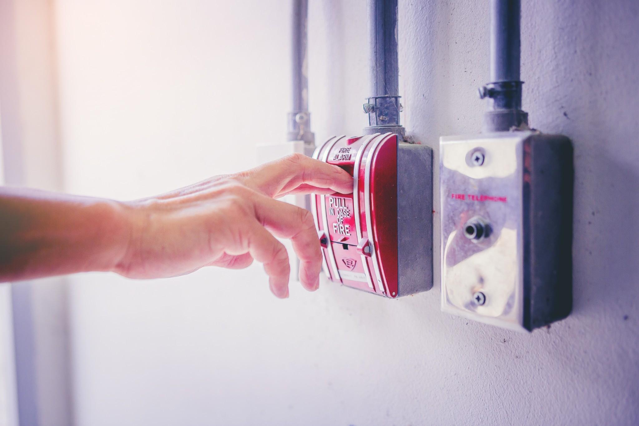Person activating a commercial fire alarm pull station