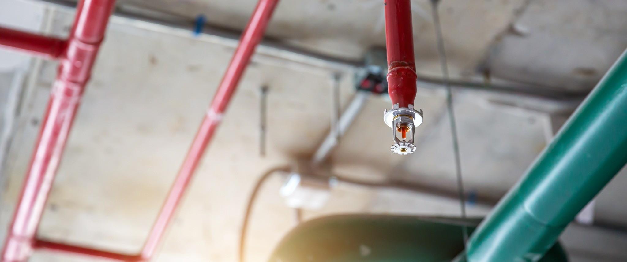 Pendant fire sprinkler head installed beneath commercial piping
