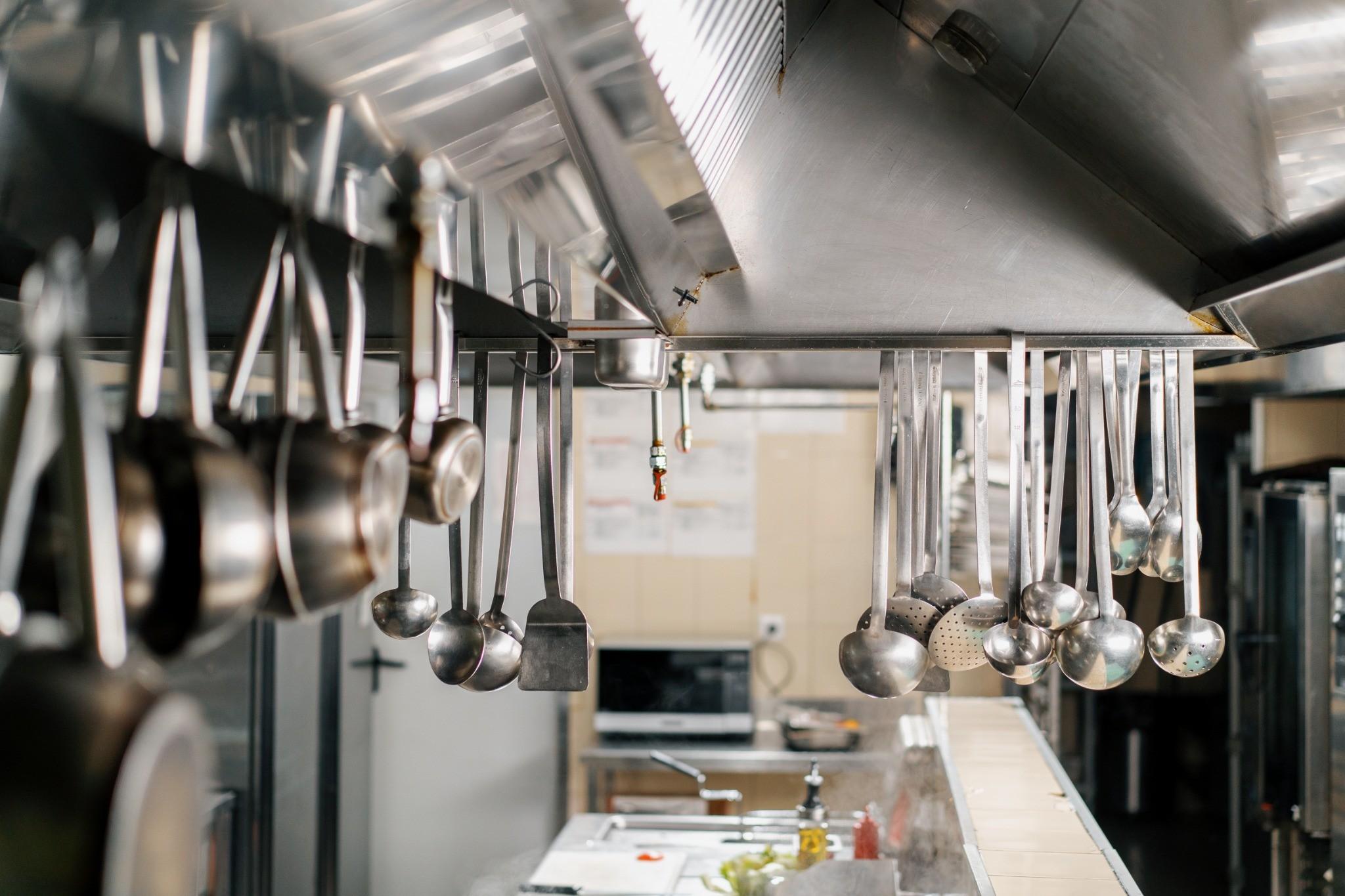 Commercial kitchen hood fire suppression nozzle above cooking equipment